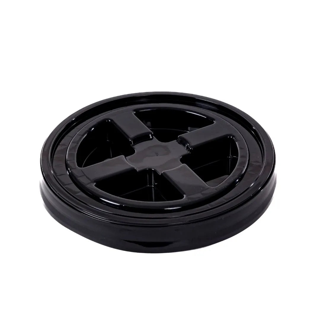 Een zwart, rond plastic deksel van een voedselcontainer met vier kruisvormige secties, zoals een gritbescherming voor een verfemmer.