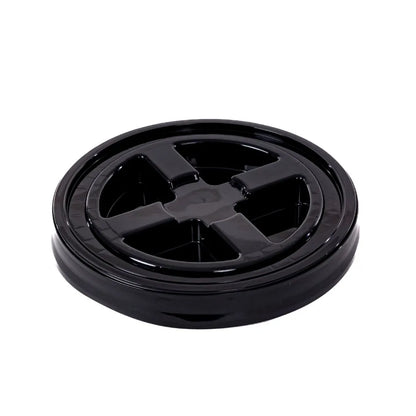 Een zwart, rond plastic deksel van een voedselcontainer met vier kruisvormige secties, zoals een gritbescherming voor een verfemmer.