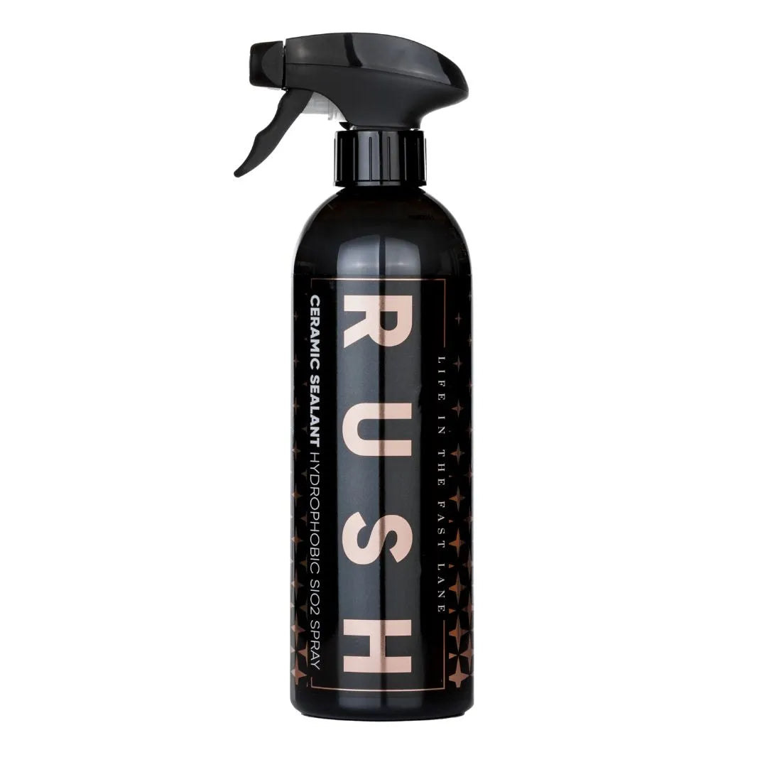 Een zwarte spuitfles met het opschrift RUSH keramische sealant Hydrophobic SiO2 Spray met een trekkerspuitmond en gouden letters voor winterbescherming auto.