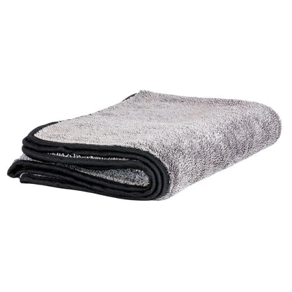 Een gevouwen grijze microvezeldoek met zwarte bies, perfect voor het aanbrengen van keramische verzegeling of autoshampoo, geplaatst op een wit oppervlak.
