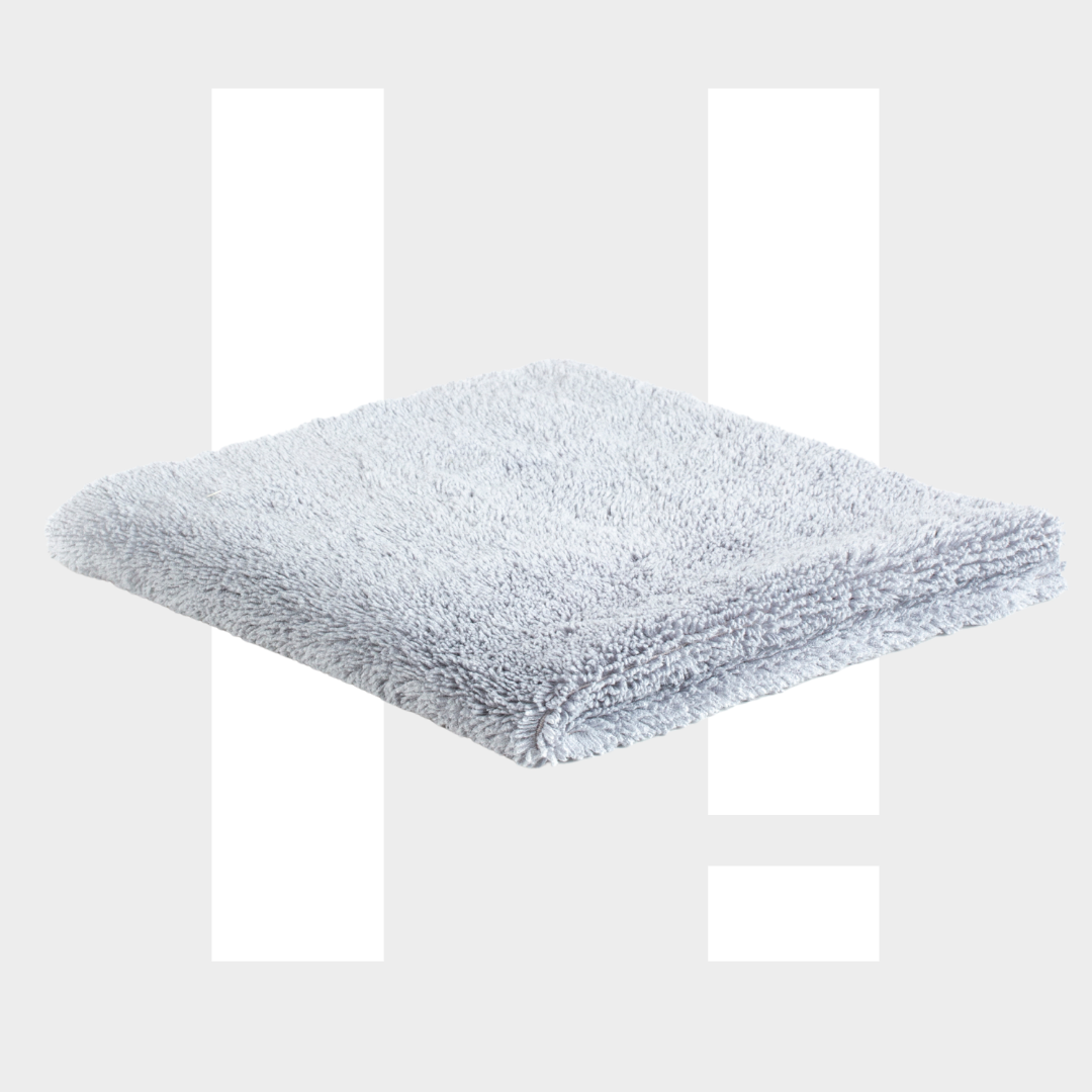 Een gevouwen RUSH Allround Interieurdoek ligt op een witte achtergrond, met witte balken erachter - ideaal voor interieurreiniging auto.