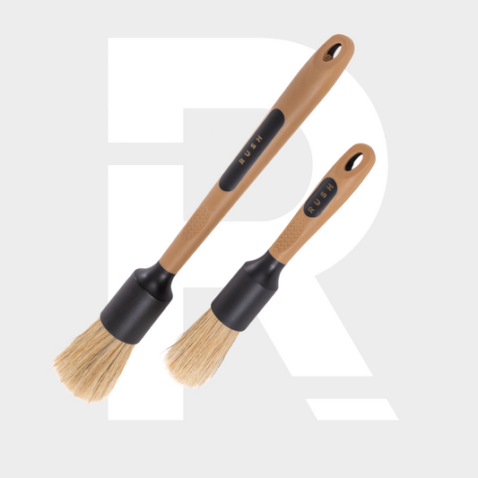 Two brown-handled Detail Brush Set brushes, one larger than the other, rest on a light background with a faint white "R"—perfect for auto cleaning.
