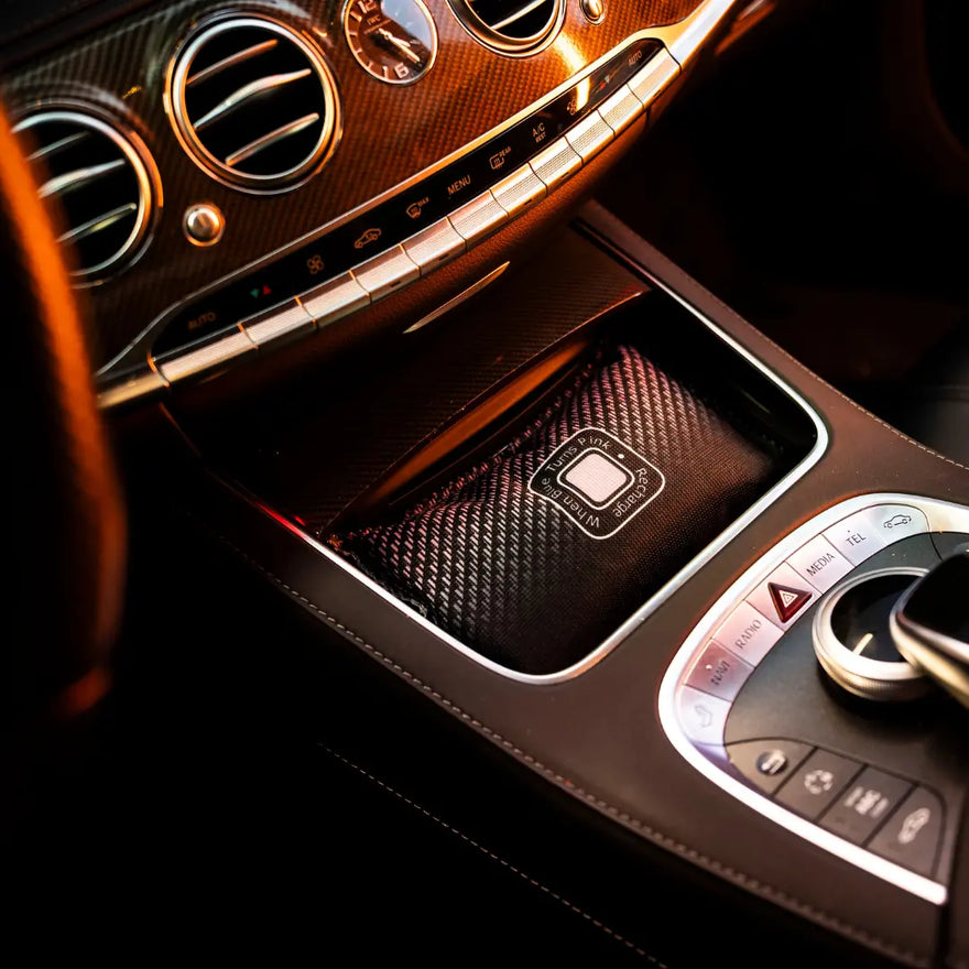 Close-up van de middenconsole van een luxe auto met bedieningsknoppen en koolstofvezel paneel - perfect om beslagen ruiten te voorkomen.