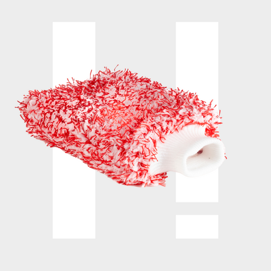 Een rood-witte microvezel washandschoen met groot absorberend vermogen op een lichtgrijze achtergrond met witte rechthoekige vormen.