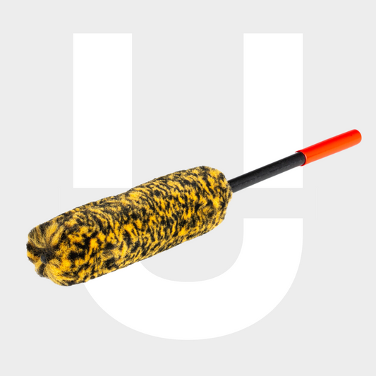 Een cilindervormige geel met zwarte Wheelie Medium duster met een rood uiteinde, afgebeeld op een lichte achtergrond met een grote witte U-vorm.