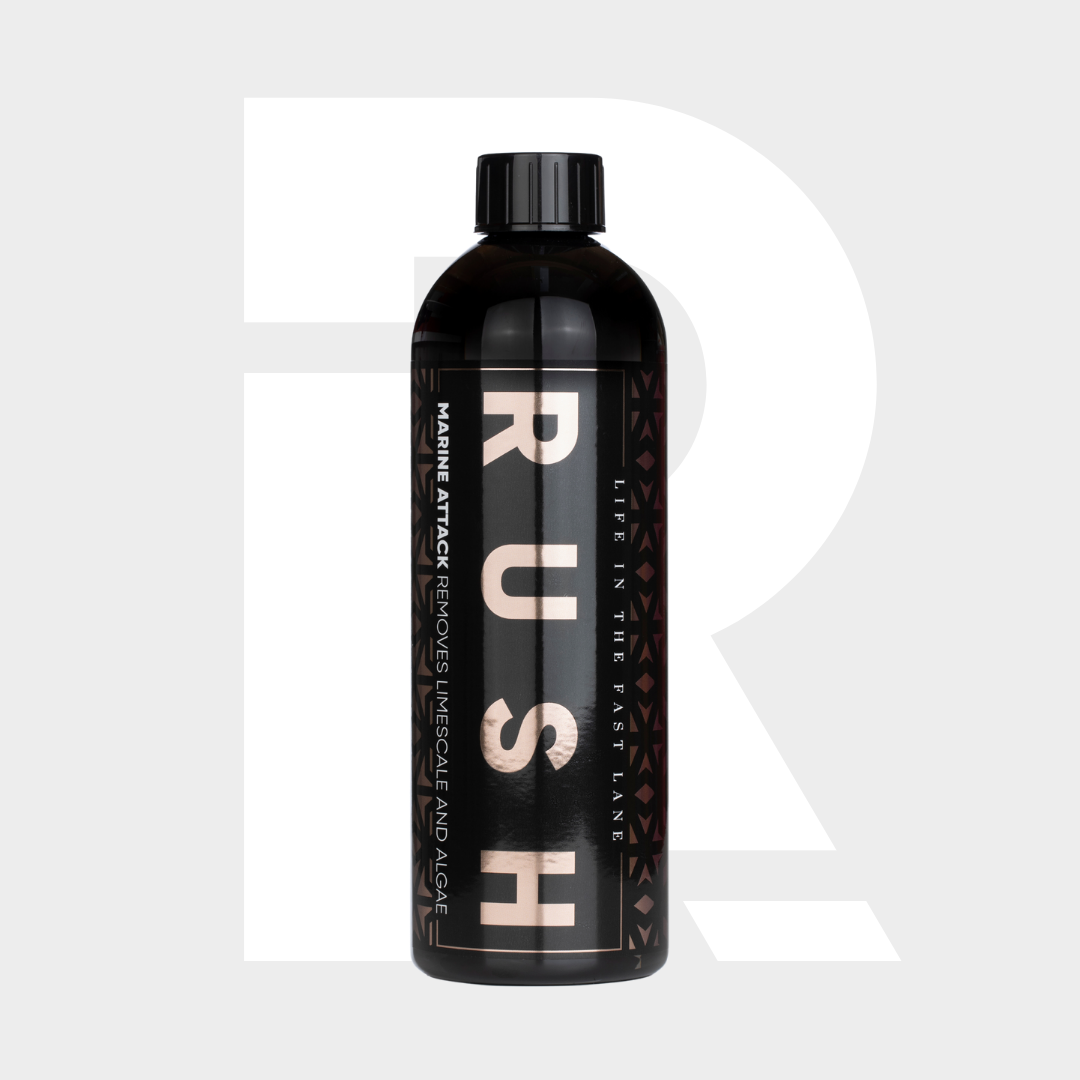 A black bottle labeled "1+1 GRATIS Marine Attack" with metallic letters and patterns stands upright. The label states: kalkanslag verwijderen en boot reinigen, biologisch afbreekbaar. A large faded R appears in the light gray background.