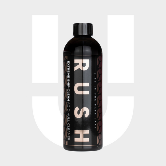 Een zwarte fles met het etiket RUSH Extreme, een zuurhoudende vaaraanslagverwijderaar, staat rechtop tegen een witte achtergrond met een grijze U-vorm.
