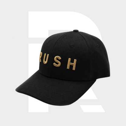 The RUSH Baseball Cap features “RUSH” embroidered in gold on the front. This black, adjustable cap is displayed against a light grey background.