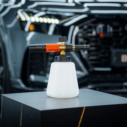 Een Foam Cannon Pro met witte container en messing mondstuk zorgt voor dik schuim tijdens het autowassen, geplaatst voor een zwarte auto.