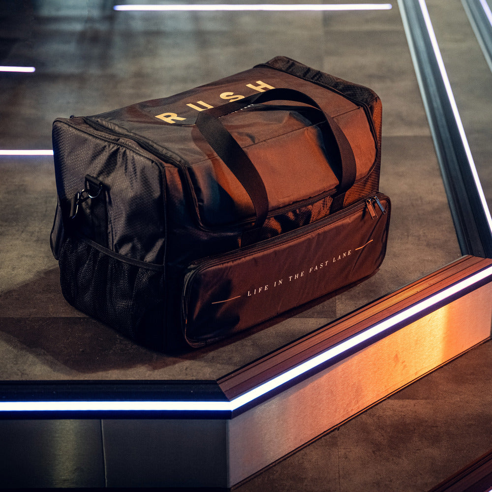 Een RUSH Detailing Bag met het label LIFE IN THE FAST LANE ligt op een tegelvloer, perfect voor schoonmaakproducten opbergen.