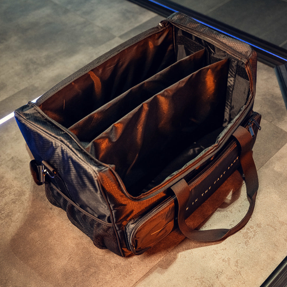 Een zwartbruine RUSH Detailing Bag met twee verdelers, zijvakken en handvatten ligt open op een tegelvloer.