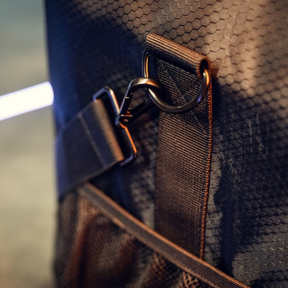 Close-up van een RUSH Detailing Bag, een zwarte ruime opbergtas met zeshoekig patroon en riem, perfect voor schoonmaakproducten opbergen.