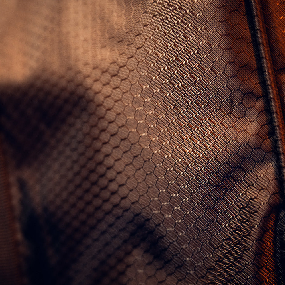 Close-up van een netstof uit de RUSH Detailing Bag, ideaal voor schoonmaakproducten opbergen, in warme bruintinten met lichte speling.