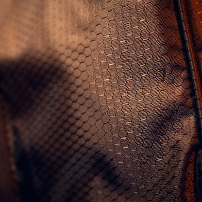 Close-up van een netstof uit de RUSH Detailing Bag, ideaal voor schoonmaakproducten opbergen, in warme bruintinten met lichte speling.