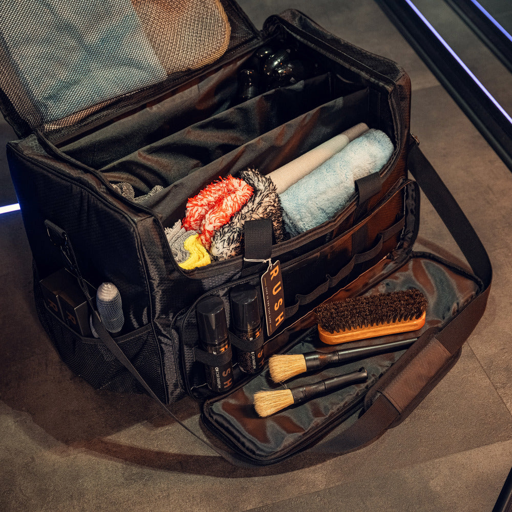 Een open RUSH Detailing Bag met handdoeken, borstels, spuitflessen en schoonmaakproducten opbergen in het ruime voorvak.