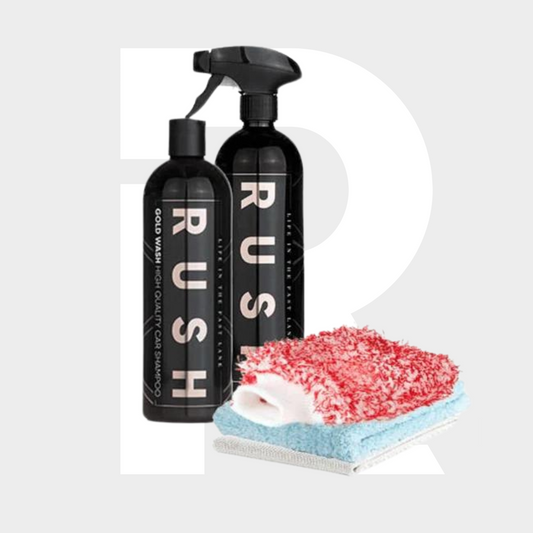The Shiny Bike Package features two black RUSH bottles—a spray wax and shampoo—placed beside a red and white wash mitt and a folded blue microfiber cloth, making it ideal for keeping your bike gleaming.