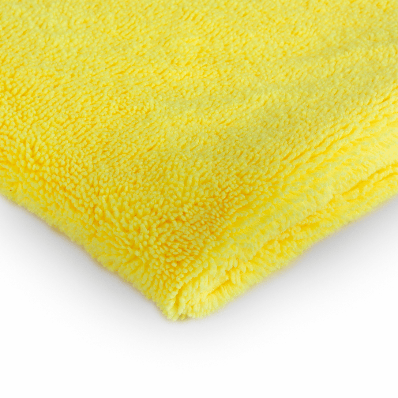 Een gevouwen geel microvezeldoek auto interieur op een wit oppervlak, dat het zachte en gestructureerde materiaal benadrukt.