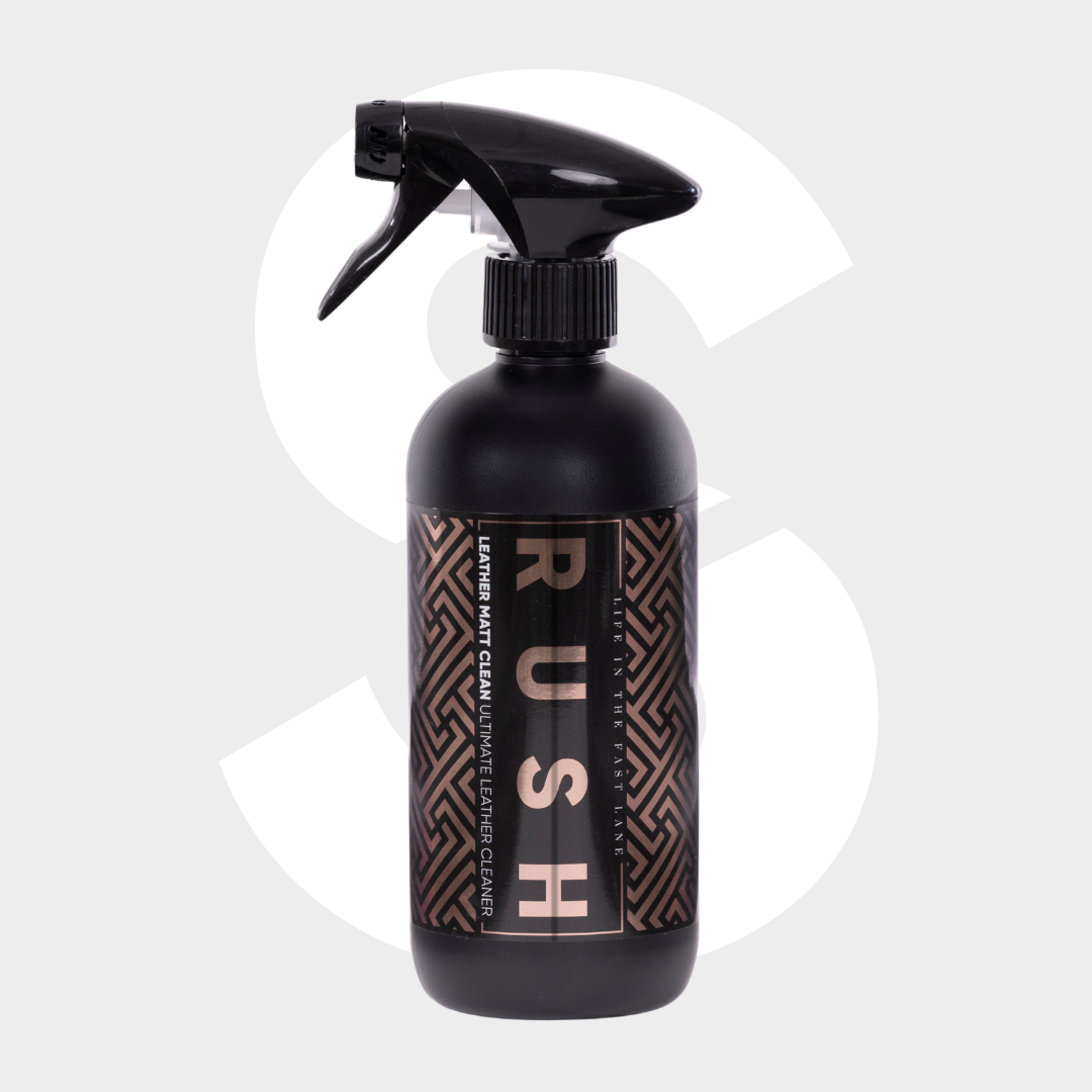 A black spray bottle labeled "Leather Matt Clean" with a geometric pattern sits on a light gray background featuring a large faded dollar sign—ideal for cleaning lederen autobekleding and achieving a matte finish.