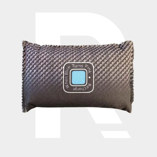 Een rechthoekige, donkergrijze auto-ontvochtiger met een indicatielabel om te helpen beslagen ruiten te voorkomen; wordt roze als opladen nodig is.