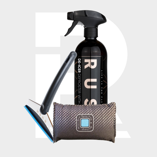 The RUSH Winter Essentials Package, featuring a black de-icer spray, a blue and black ice scraper, and a small textured pouch, is displayed on a light background with bold white lettering.