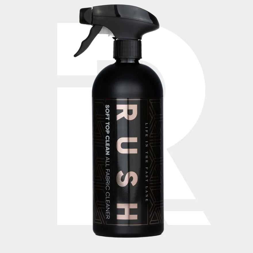 A black spray bottle labeled Soft Top Clean with gold and white text sits on a light grey background with a faint large "R"—ideal for cleaning cabriolet roofs and boat covers.