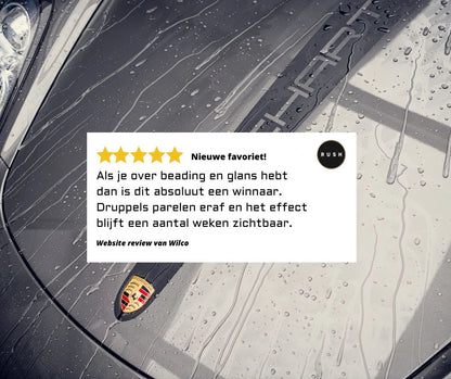 Regendruppels op de motorkap van een Porsche benadrukken het extreme waterafstotende effect van de spraywax, beoordeeld door een Nederlandse gebruiker.